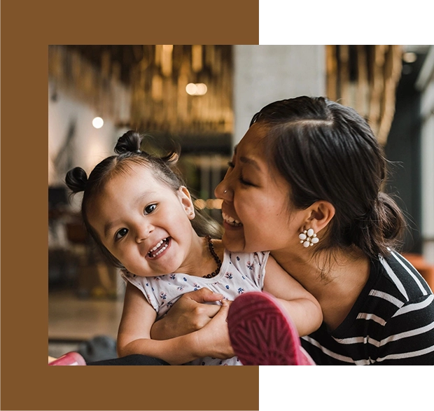 A woman holding a baby and smiling.