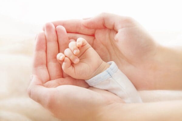 A baby hand on an adults hand