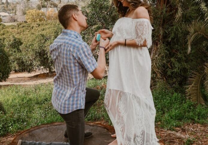 A man kneeling down to propose to his girlfriend.